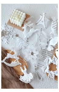 Close-up of white glittery Christmas ornaments featuring reindeer and snowflake shapes