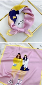 Detail of pink silk scarf with cartoon fashion print and yellow hem on velvet surface