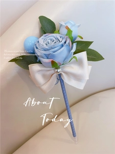 Blue artificial silk rose boutonniere with cream ribbon and pearl accents on leather