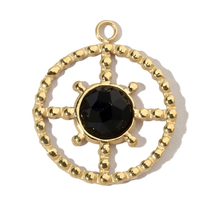 Macro detail of gold-plated geometric ring pendant with black faceted gemstone