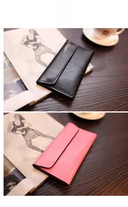 Lange Ledergeldbörsen in Schwarz und Rosa auf Holztisch mit Lifestyle-Requisiten