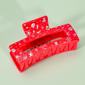 Detail of red acrylic hair claw clip with holographic Christmas snowflake patterns