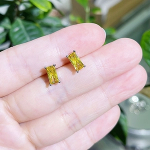 Detailed view of rectangular lemon yellow zircon stud earrings in a four-prong setting