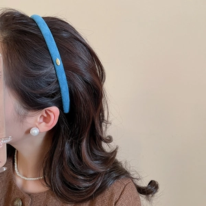 Vue latérale d'un serre-tête en velours bleu Klein avec étiquette Love dorée