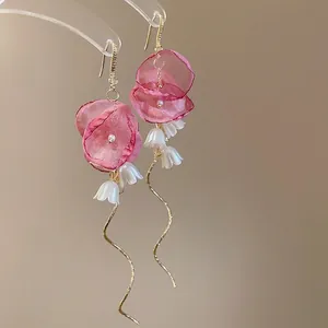 Elegant floral tassel earrings with pink fabric petals, pearls and long gold wavy lines