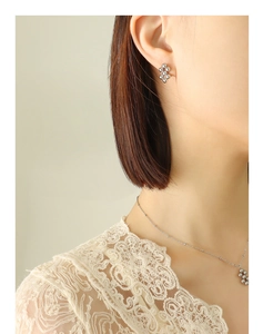 Detail of silver steel ball cluster necklace and matching stud earrings on a model