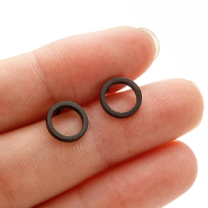 Minimalist matte black geometric hollow circle stud earrings shown on fingers for size