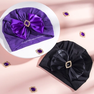Detailed view of baby turban hats with oversized bows and rhinestone centerpieces