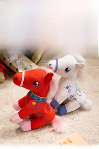 Detail of red and white plush horses with intricate floral embroidery and soft textures