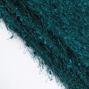Detailed close-up of dark green textured fuzzy fabric with long plush fringe texture