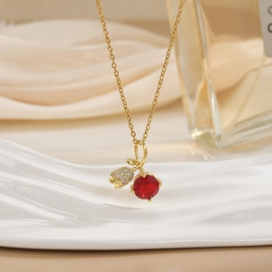 Detail of gold necklace featuring red zircon pendant and pavé-set bud element charm