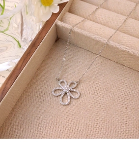 Close-up of sparkling zircon flower pendant on silver titanium steel chain