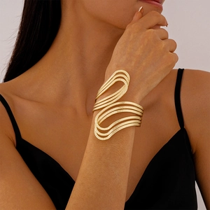 Close-up of irregular layered gold bangle with brushed texture on model's wrist