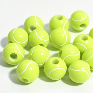Detail of neon yellow tennis ball beads with white curved lines for DIY jewelry crafting