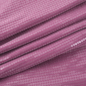 Macro view showing the texture of shimmering sequins on this mauve party dress fabric