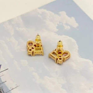 Close-up of gold-plated CD earrings featuring sparkling pink zircon crystal inlay