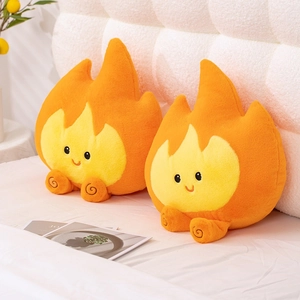 Creatief vlam pluche kussen met lachend gezicht en zachte oranje stof op wit bed