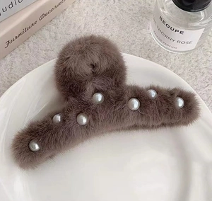 Détail d'une grande pince à cheveux en peluche marron avec perles élégantes
