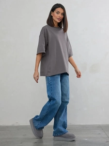Inquadratura completa di una maglietta grigia in cotone e jeans blu dallo stile casual