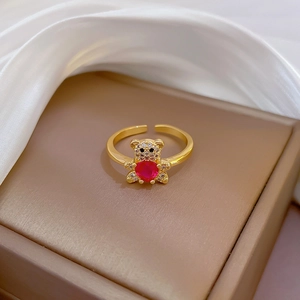 Detail of bear-shaped open ring with red gem and gold plating on jewelry box