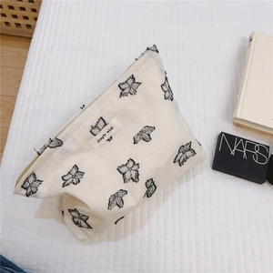 Detail of minimalist cream canvas bag with floral embroidery and simple wish label