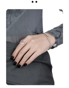 Macro detail of silver ginkgo leaf ring and pave crystal bracelet on model