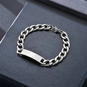 Close-up of a polished silver Cuban chain bracelet with a blank engravable ID plate