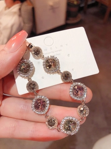 Close-up of rose gold bracelet with brown and purple square crystals and diamond halo