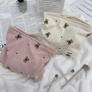 Detail of pink and beige corduroy pouches with cute bear embroidery and heart accents