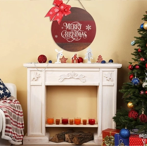 Merry Christmas wooden sign with red bow hanging on wall above a white fireplace