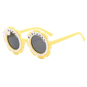 Bright yellow flower shaped kids sunglasses with white pearls and Happy Birthday letters