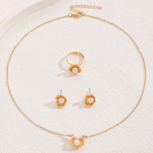 Elegant gold jewelry set with flower-shaped pearls including necklace, ring, and earrings
