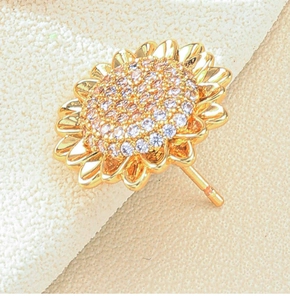 Detailed view of sunflower stud earrings with gold metal petals and sparkly zircon center