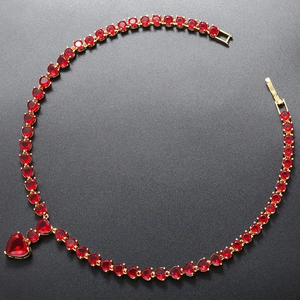 Detailed top view of luxury gold heart necklace with red rubies and pavé diamonds