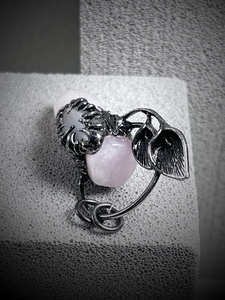 Detailed macro shot of vintage silver vine ring with an irregular pink crystal stone