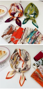 Close-up of pleated satin scarf with floral prints arranged with lifestyle props