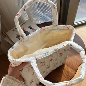 Detailed interior of a white quilted tote bag with bear print and spacious cotton lining
