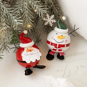 Christmas iron ornaments featuring Santa Claus and snowman on a tree branch
