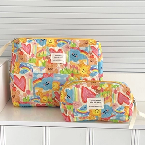 Detail view of two quilted cosmetic bags with colorful cartoon heart and sun prints