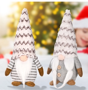 Detail of two Nordic Christmas gnomes with knitted hats in a festive indoor scene