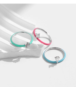 Close-up of three colorful enamel rings with round, square, and pear-cut cubic zirconia