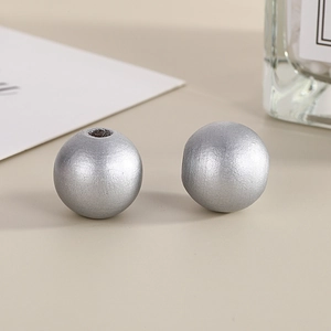Macro shot of 16mm round silver painted wooden beads with textured finish for DIY jewelry
