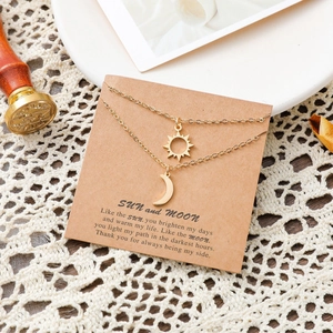Collier double rang doré soleil et lune en acier inoxydable sur une carte cadeau