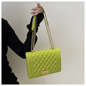 Detail of neon green quilted chain bag with gold hardware and secure metal lock