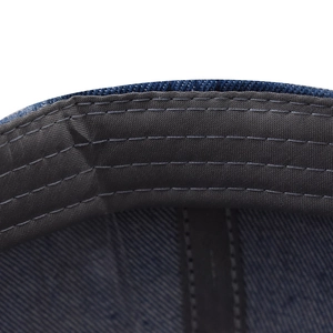 Détail des coutures renforcées sur la visière de la casquette en jean avec bande