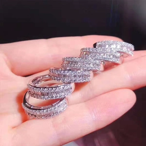 Detail showing five silver heart-shaped rings with full-set pave crystal stones on hand