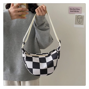 Detail of checkered hobo bag showing adjustable white strap and black and white pattern
