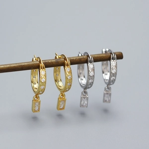 Detailed macro of gold and silver S925 star hoop earrings with zircon pendants