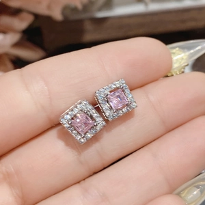 Detailed close-up of pink square gemstone earrings with halo diamonds and silver setting