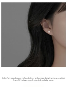 Detailed close-up of 925 sterling silver white rose stud earring on model's ear